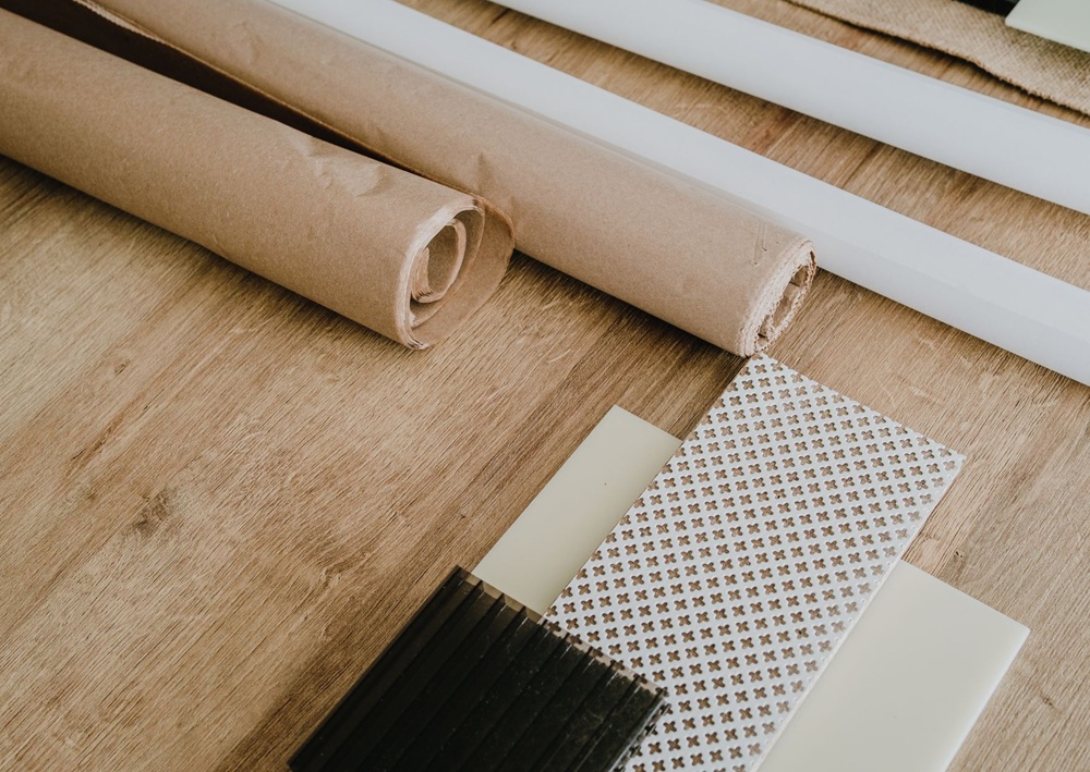 Rolled wallpaper, wood flooring, patterned fabric, and neutral samples displayed for interior design coordination.
Image name: Contemporary Living Design